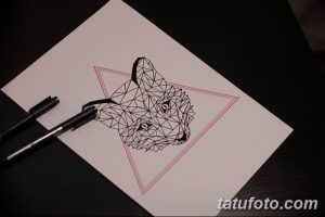 Черно-белый эскиз татуировки лисы, помещенной в треугольник. Лиса выполнена в геометрическом стиле, с использованием множества линий и углов.